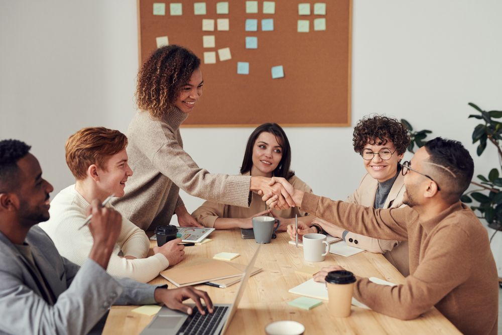 People greeting one another around a shared table